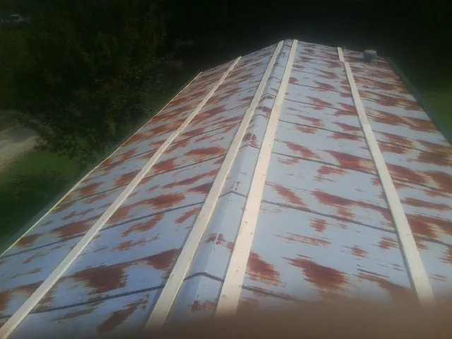Rusted metal roof panels with new wood purlins before replacement — Storm Damage Roof Repair in Balch Springs by Roofing Brothers