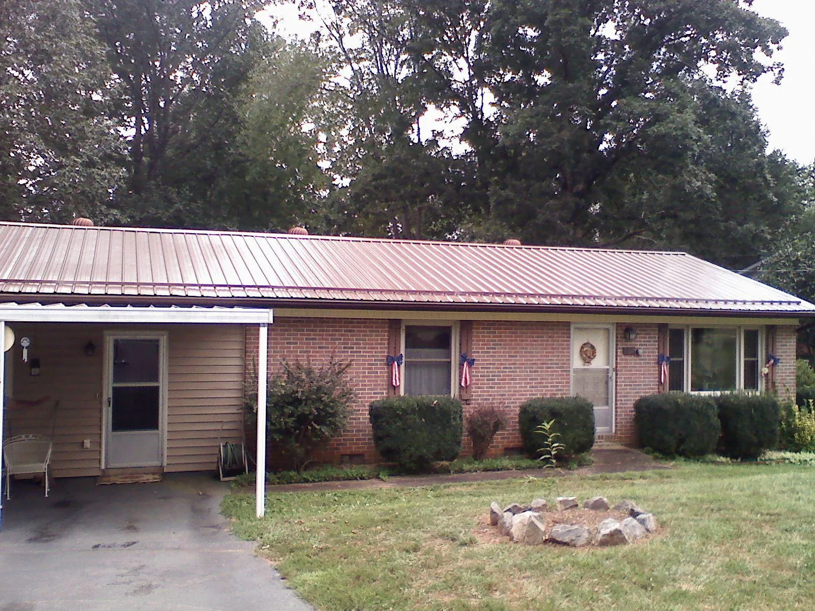 Bronze metal roof and carport on a brick ranch home — Roof Repair work by our crew in Balch Springs